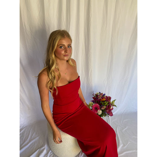 Red strapless full length dress. Top bit of dress has boning like a corset an zip up back. Size XS best fitted to a 8 - small 10. Slight above view or dress with person sitting on chair