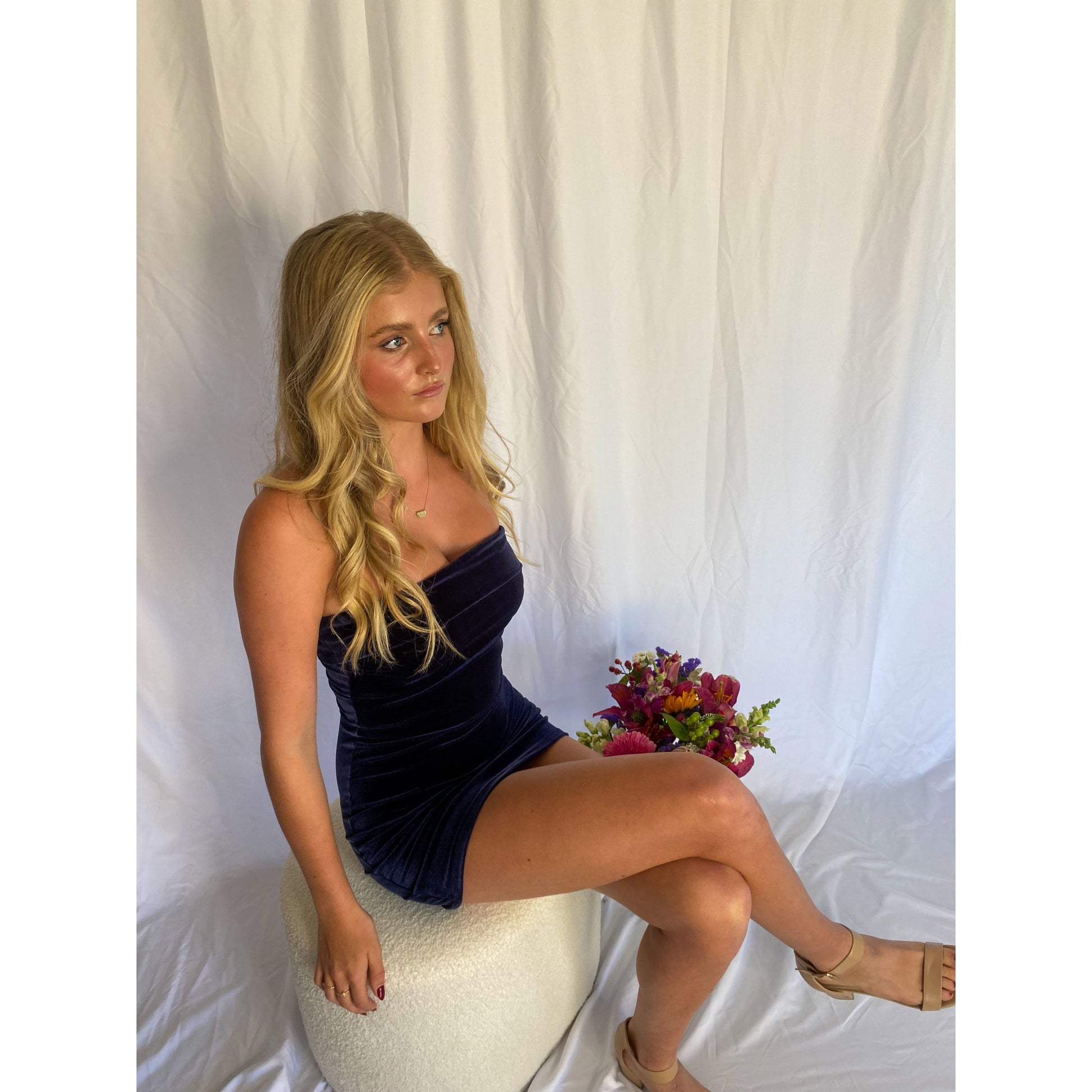 7th and York Strapless Mini Dress in Midnight (Navy), Velvet Material. Perfect for events like the races, birthdays etc. Size 8/S dress. Sitting down on chair view off dress