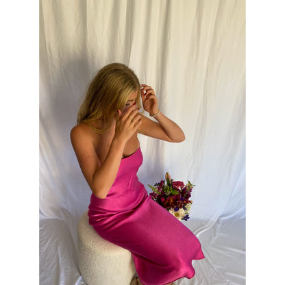 Bec and Bridge Moondance Midi Dress in Hot Pink, Size 6 and 10. Perfect for events like formals, 21sts, races etc. Silky/Satiny feel slight flow to dress. Sitting view of dress. 