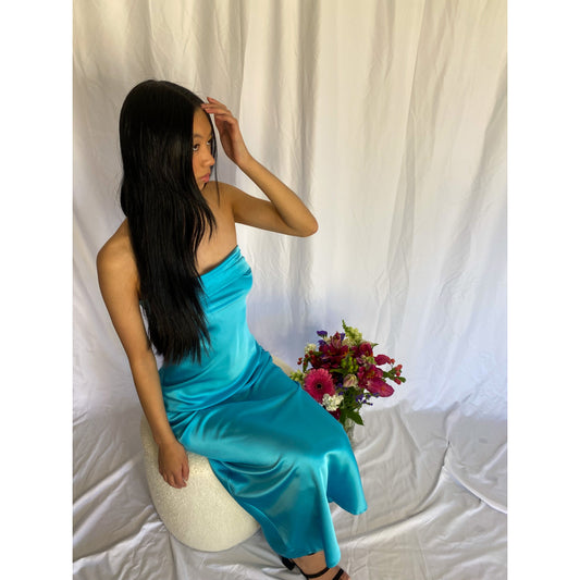 Miya Maxi in Turquoise Blue, Size 8/S. Strapless design with a tight yet flowy satiny material with a zip up side. Perfect for races, graduation, formals etc. Front sitting down view of dress.