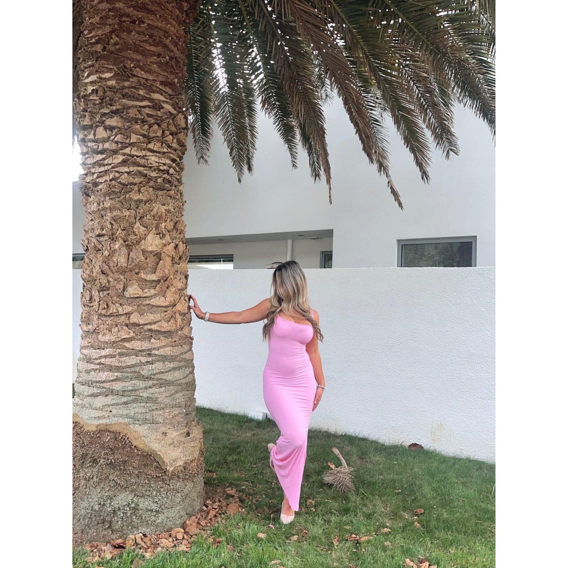 SKIMS Long Slip Dress in Cotton Candy Pink, Size M. Featuring a body hugging fit, straight neck and adjustable spaghetti straps. Can be dressed up or down. Dress can appear semi sheer depending on how much it is stretched when on. Can be dressed up or down. Front on view.