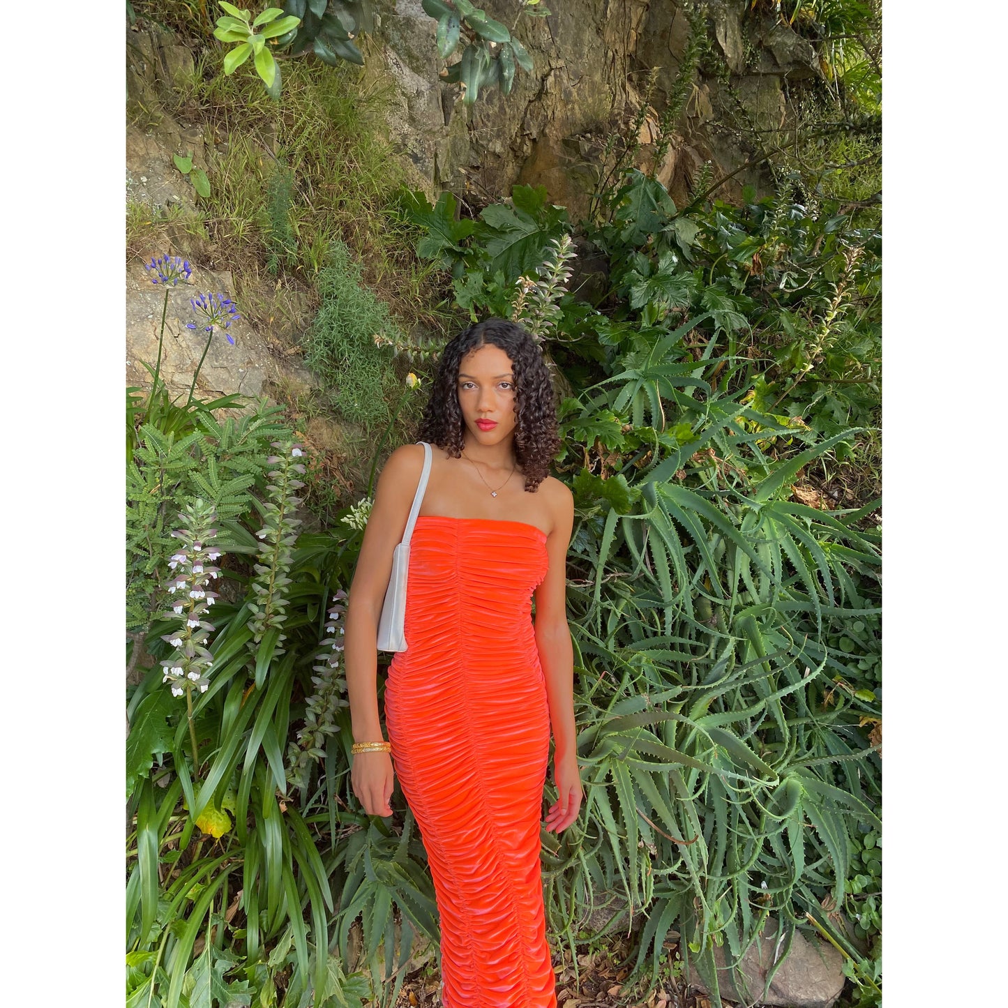 John Christopher Rogers Wiggle Dress in Orange. Best fits a Size 8. Rich velvet material this is a dress to standout in with it's almost fluorescent shade. Strapless design with zip up back. Perfect for formal events where you want to stand out. Front on view of dress.