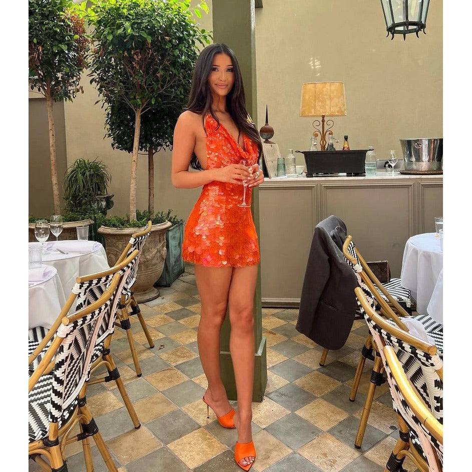 Rat and Boa Malika Mini in Orange Sequin, Size S. Featuring a big sequin design with an adjustable plunging necking and barely there ties with an open back. This is the perfect dress to stand out at an event. Front on side full length view of dress.