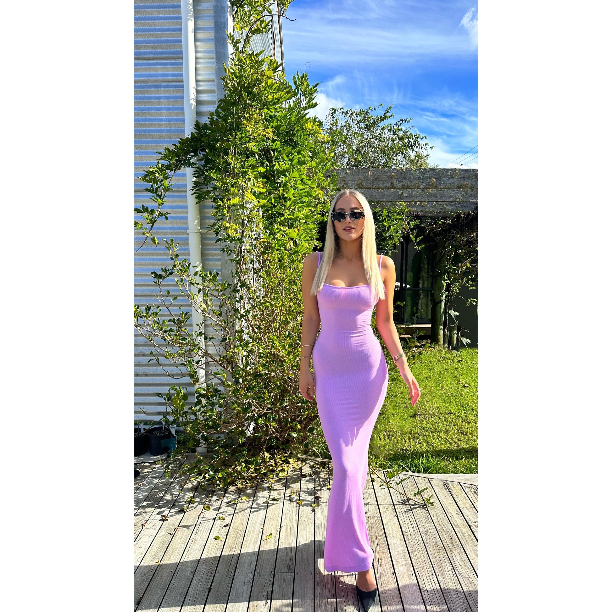 SKIMS Long Slip Dress in Petal Pink, Size XS and M. Featuring a body hugging fit, straight neck and adjustable spaghetti straps. Can be dressed up or down. Dress can appear semi sheer depending on how much it is stretched when on. Can be dressed up or down. Front on view of dress.