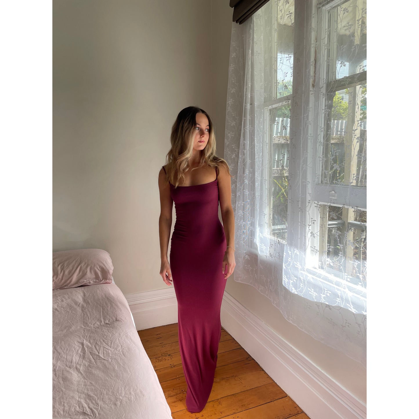 SKIMS Long Slip Dress in Wine Red, Size S. Featuring a body hugging fit, straight neck and adjustable spaghetti straps. Can be dressed up or down. Front on full length view of dress.