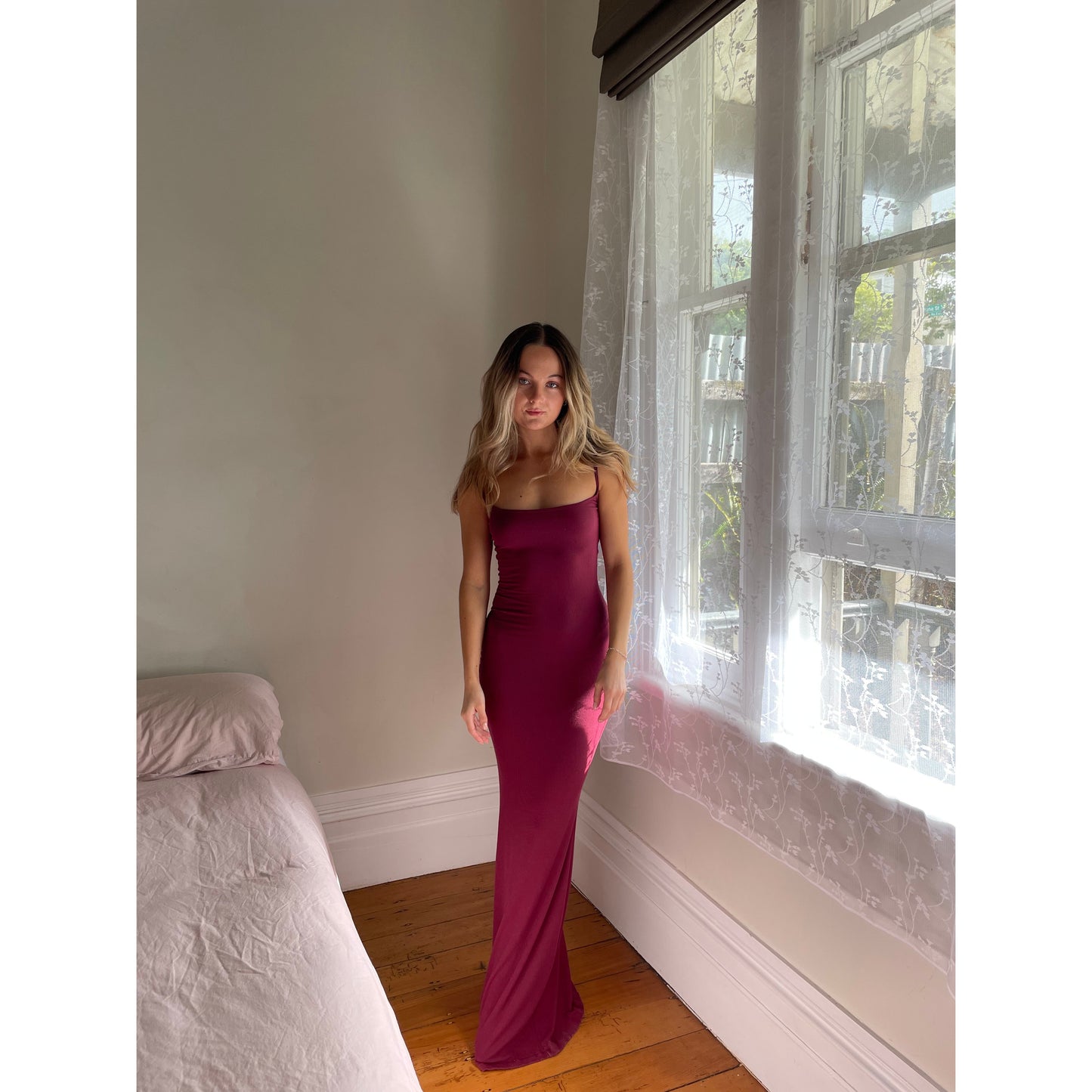 SKIMS Long Slip Dress in Wine Red, Size S. Featuring a body hugging fit, straight neck and adjustable spaghetti straps. Can be dressed up or down. Front on view of dress.