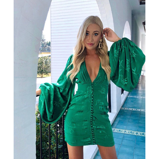 Rat and Boa Isabella Mini Dress in Green, Size S. Featuring balloon sleeves and a deep v neck with a buttoned front and zip up back. Additionally it features some floral designs in green that give off a slight shine to make it stand out against the green fabric. Perfect for parties, bottomless brunches etc. Front of view of dress.