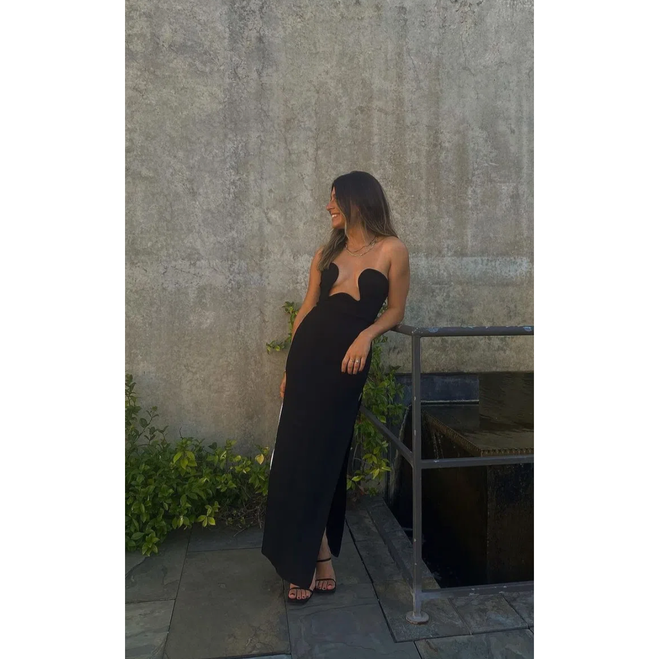 Morocco Maxi Dress in Black, Size XS and L. Featuring a unique strapless design with a zip up back and cut out area in middle of bust. This is a tight fitting dress. Split up side of dress ending mid thigh to make walking easier. This dress is best for formal events. Front on view of dress