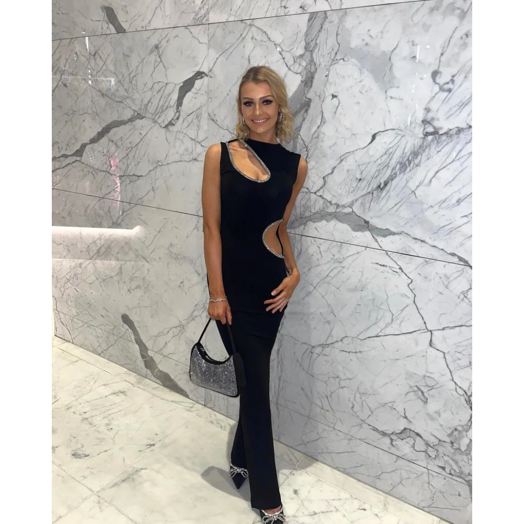 Ivona Skelo Vivia Dress in Black with Crystal Cut Outs, Size 8/S. Featuring two cut outs one at the waist and one at opposite shoulder the edge of both cut outs is covered with crystals. Perfect for formal events. Front of full length view of dress.